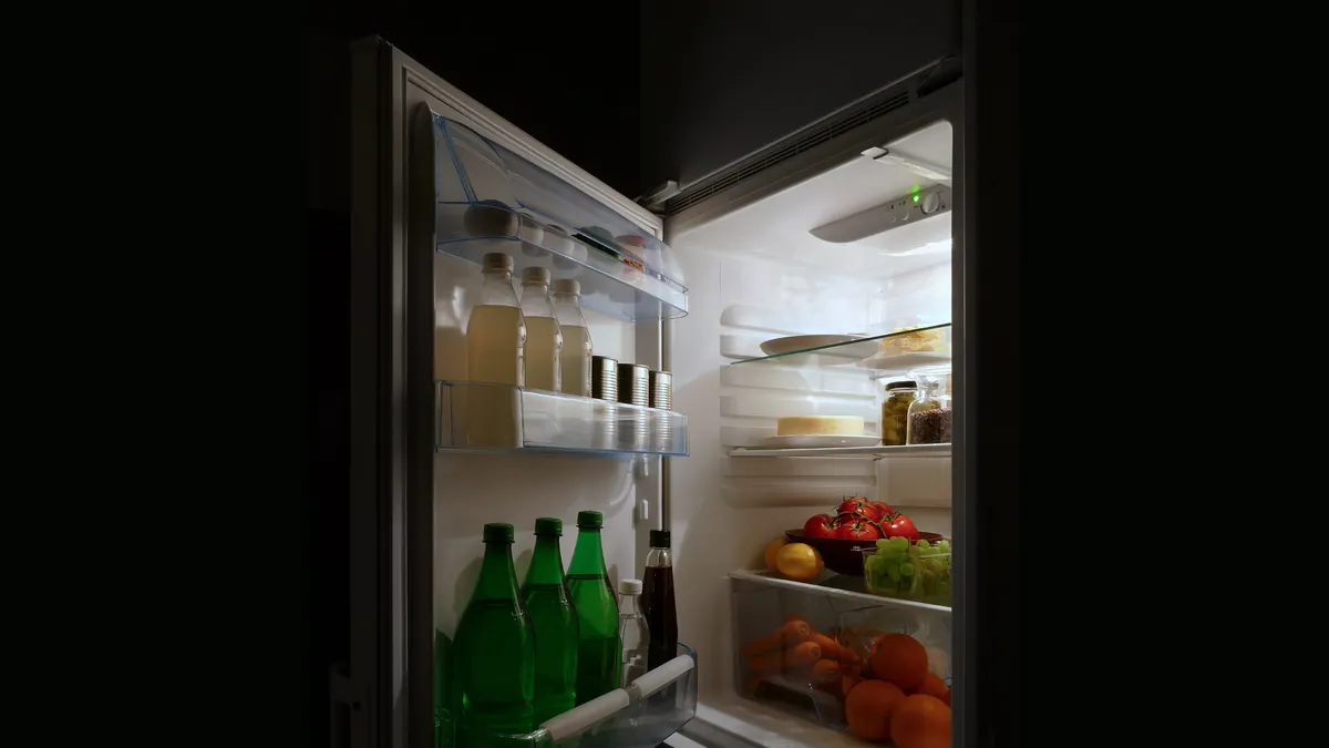 Symbolic image: an open refrigerator with food at night