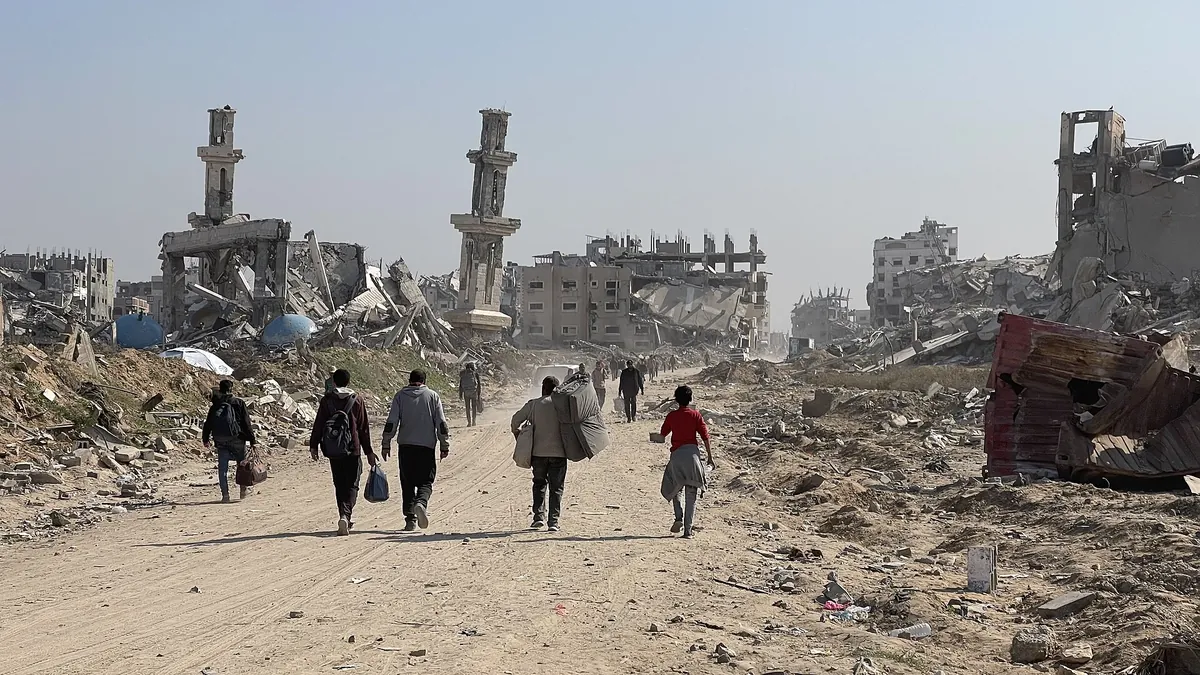 Archivbild (2025): Vertriebene Palästinenser gehen durch Trümmer im Gazastreifen